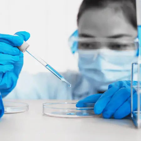 Scientist transferring liquid to petri dish in bioprocessing laboratory