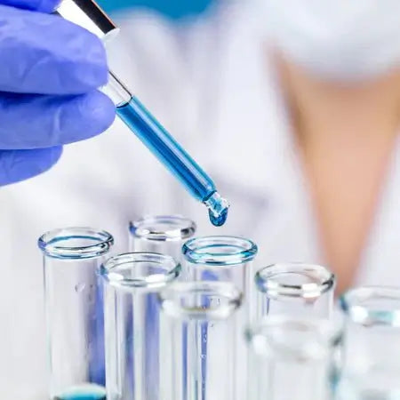 Gloved hand pipetting liquid into test tubes in a life sciences lab